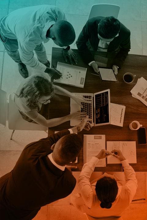 Photo of digital background with word AI on it. Generative AI. A group of people sitting around a table with laptops.