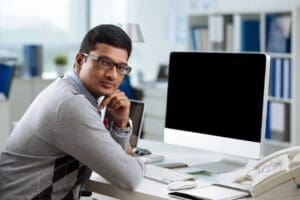 A man sitting at his desk in front of a computer.