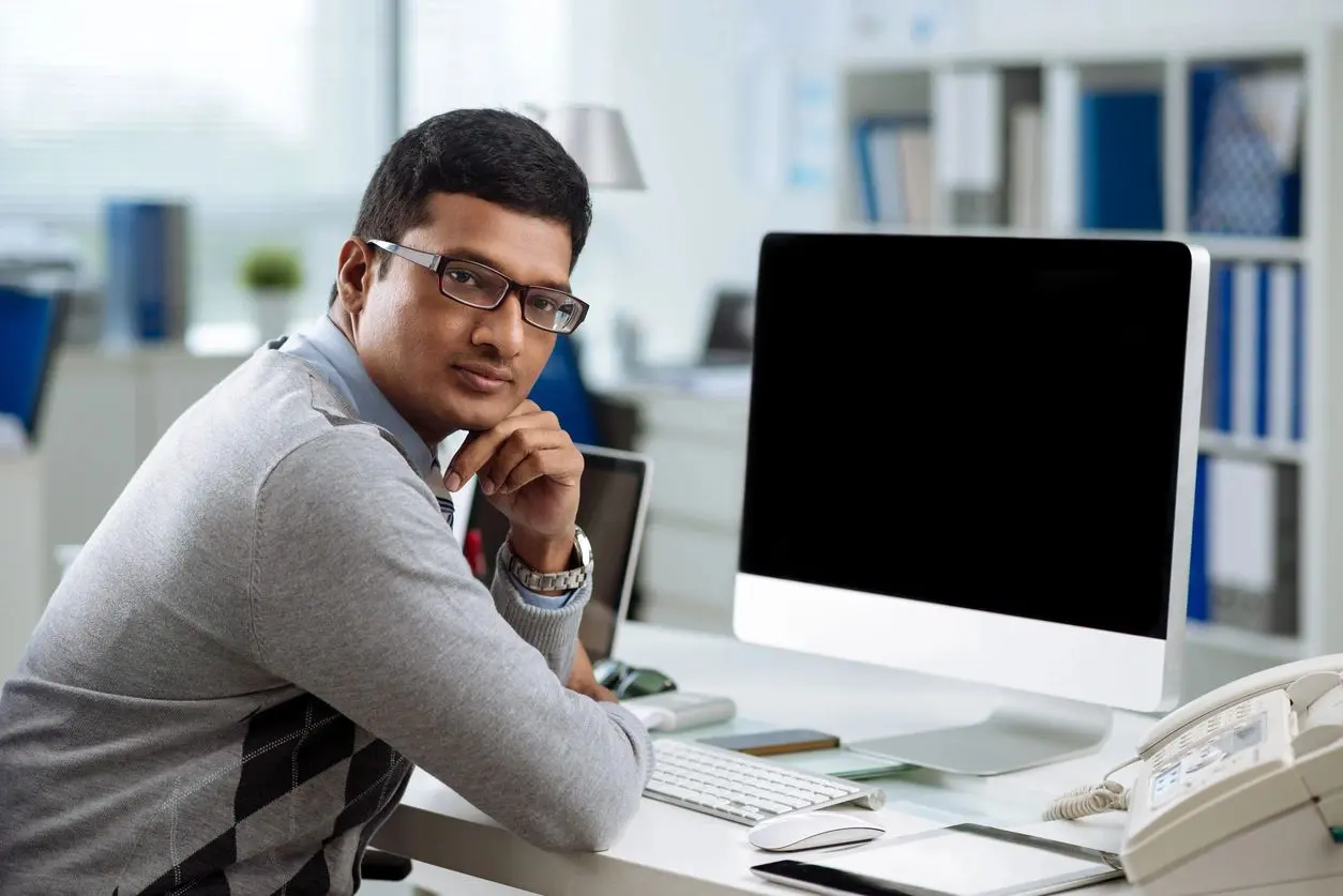 qtq80-L2ST3f A man sitting at his desk in front of a computer.